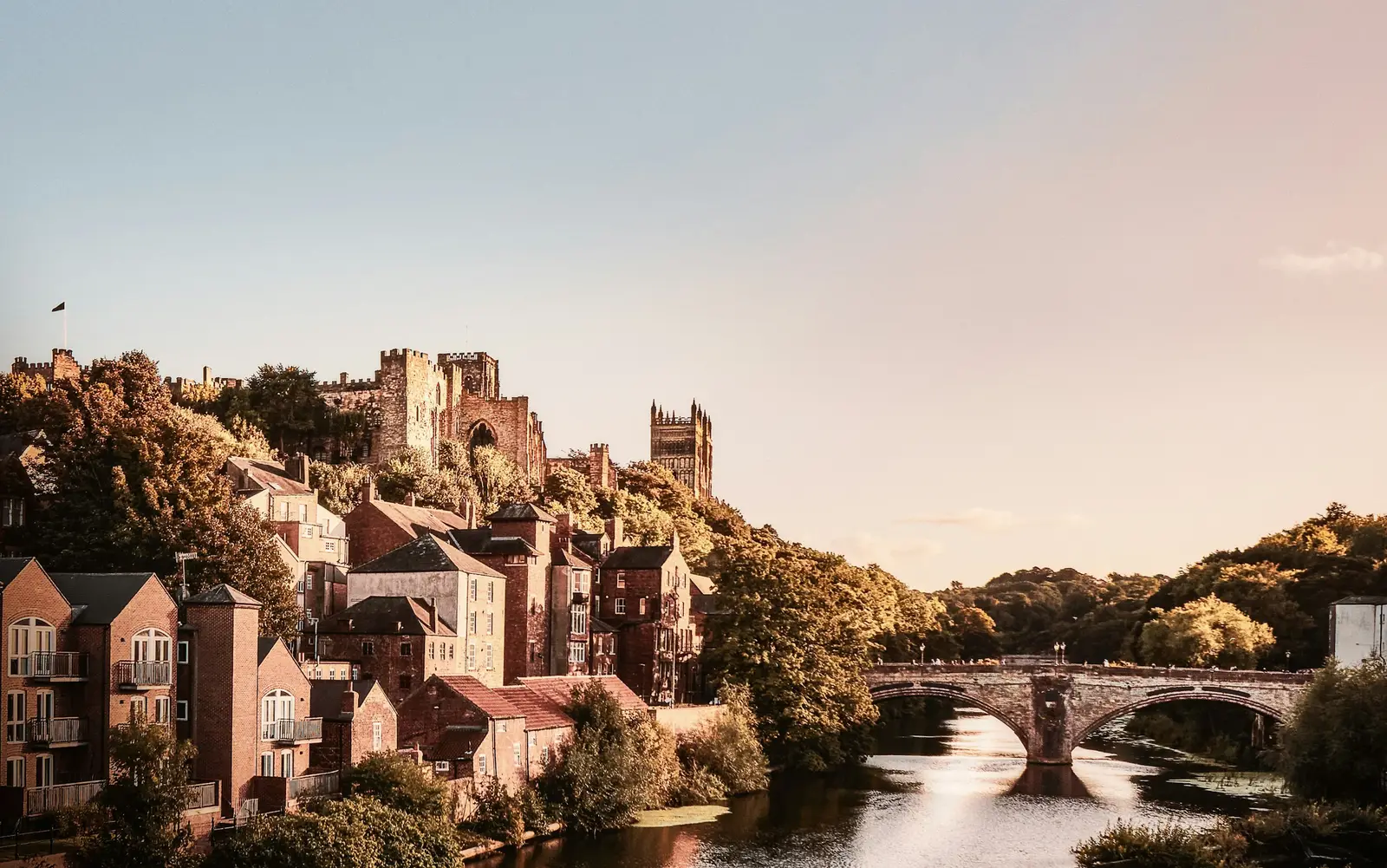 Durham Cathedral rising above autumn trees, seen from Prebends Bridge over the River Wear