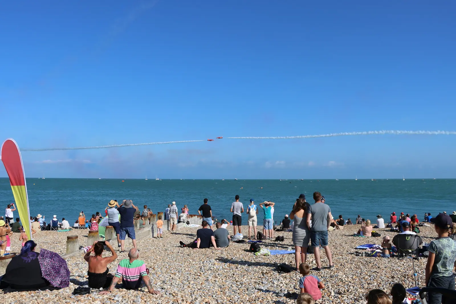 Family on Eastbourne promenade with the Victorian pier and calm sea behind