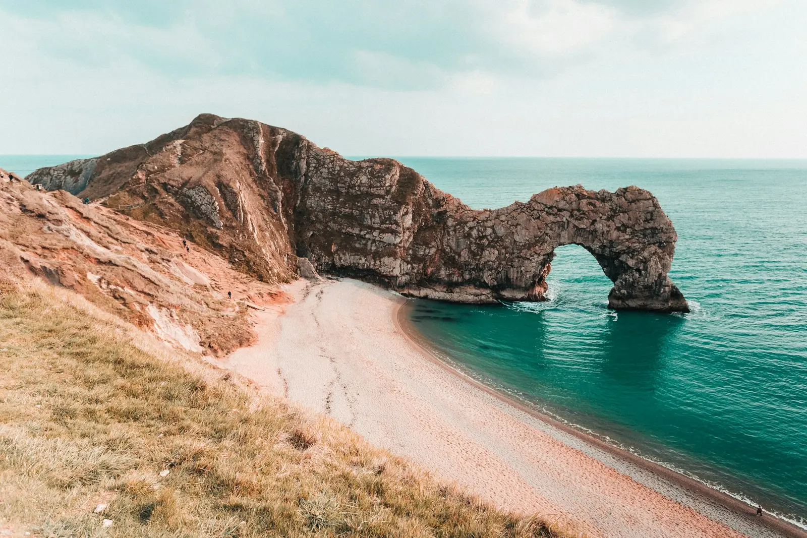 Durdle Door limestone arch above turquoise water on the Jurassic Coast at sunset