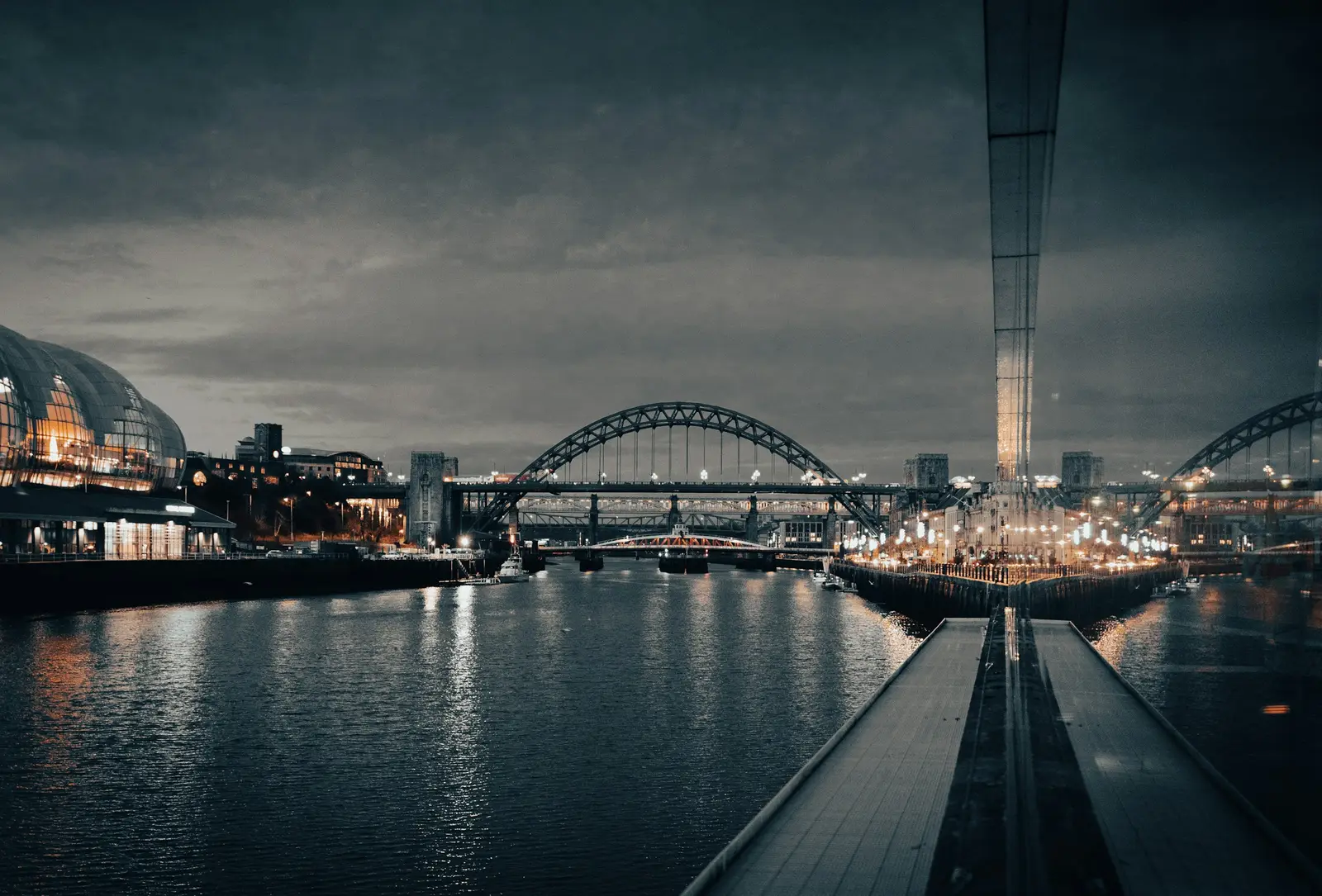 The Tyne Bridge and Gateshead Millennium Bridge lit at dusk over the River Tyne