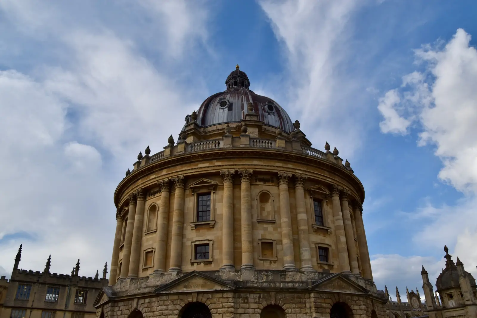 Graduate in gown in Radcliffe Square, Oxford, with the domed Radcliffe Camera behind