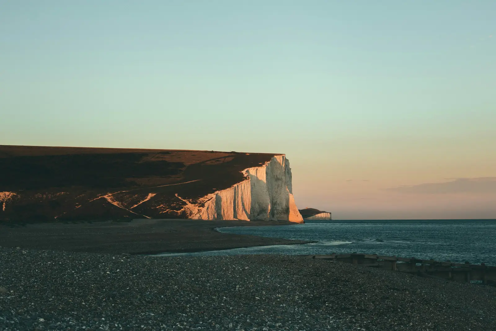 Couple on the grass at Seaford Head, well back from the edge, with the Seven Sisters cliffs behind