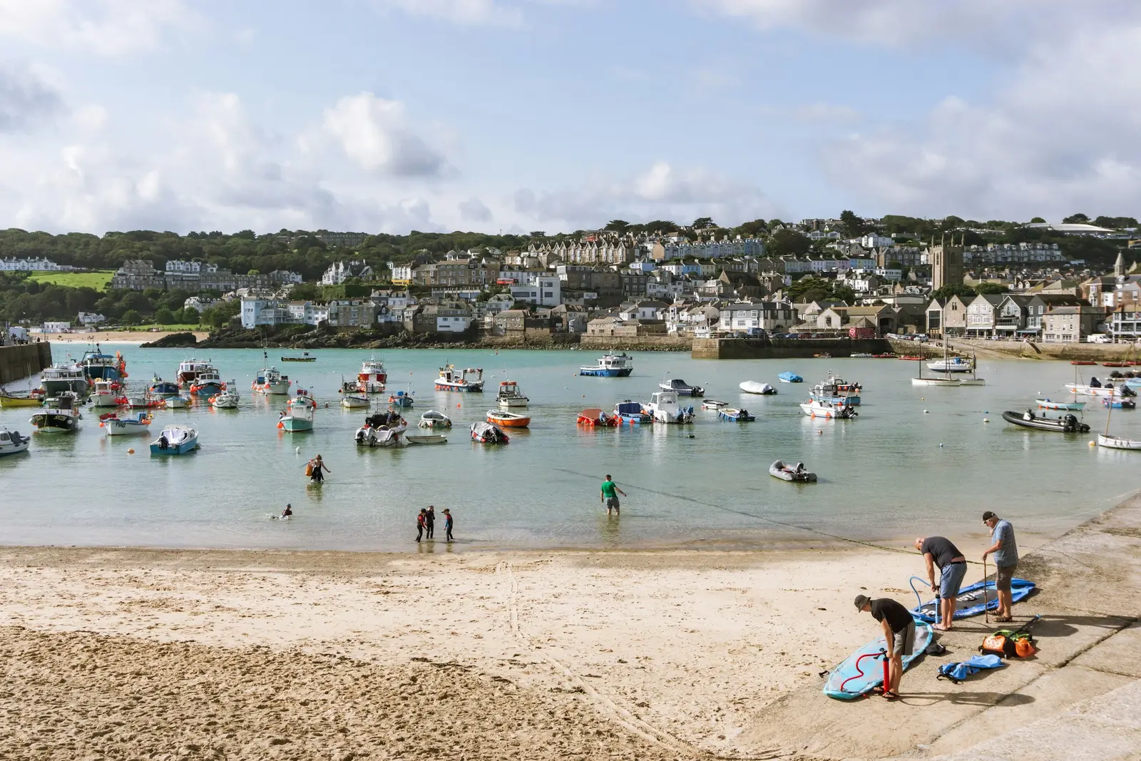 St Ives harbour at low tide with boats on the sand and granite cottages behind