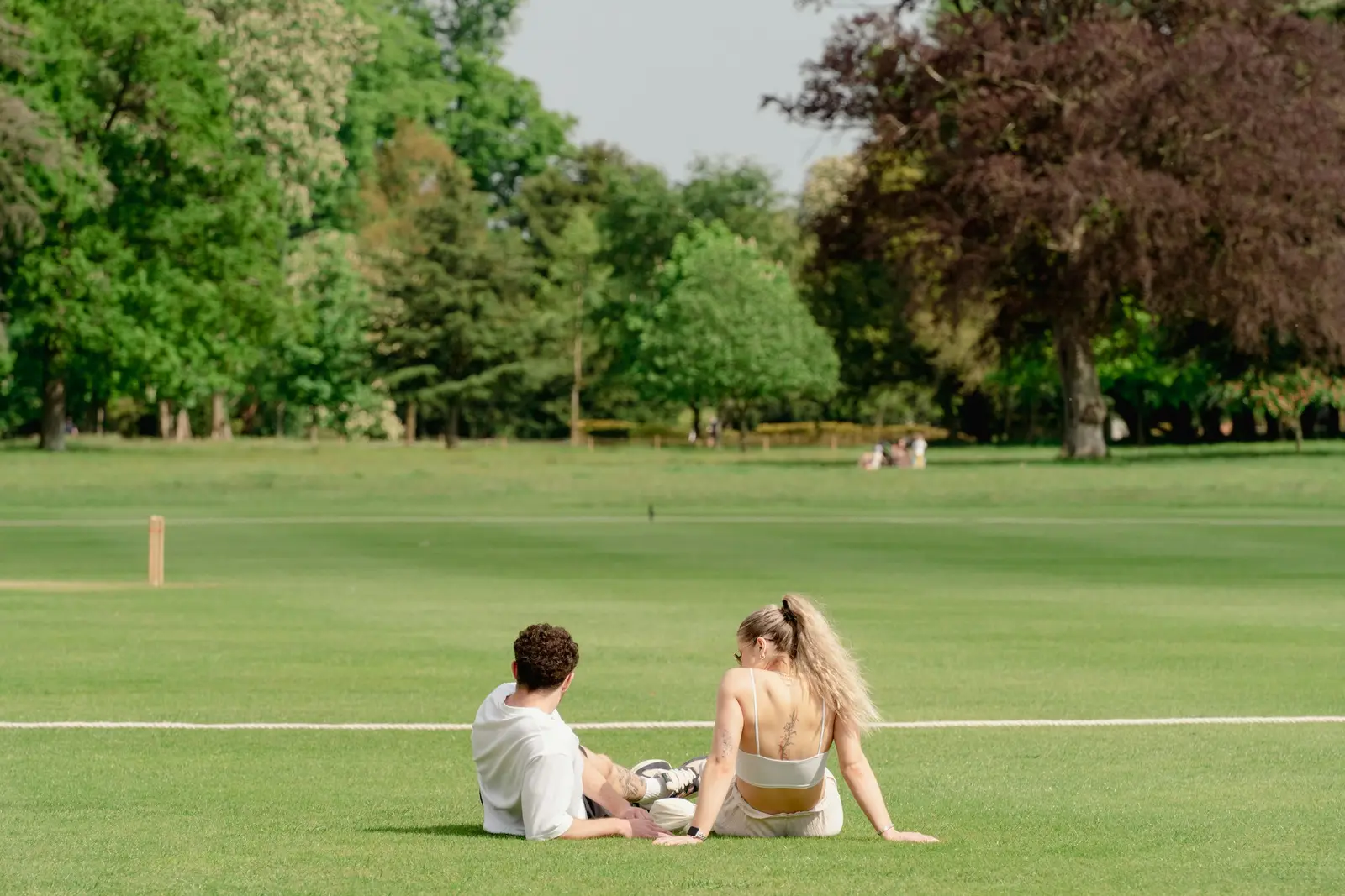 Family walking together across a London park lawn with the city skyline behind