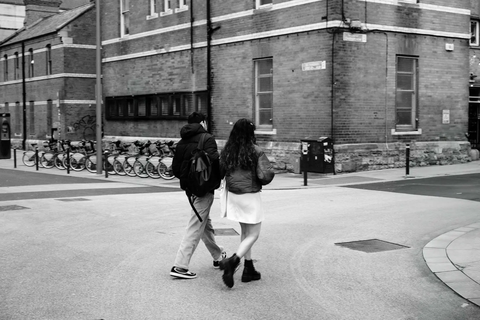 Couple sharing a clear umbrella on a rain-wet street with lamplight reflected in the pavement