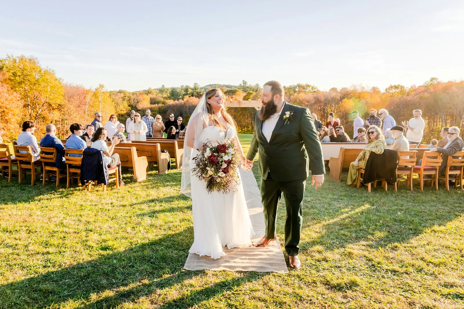 Newly married couple walking through a shower of confetti outside an English church