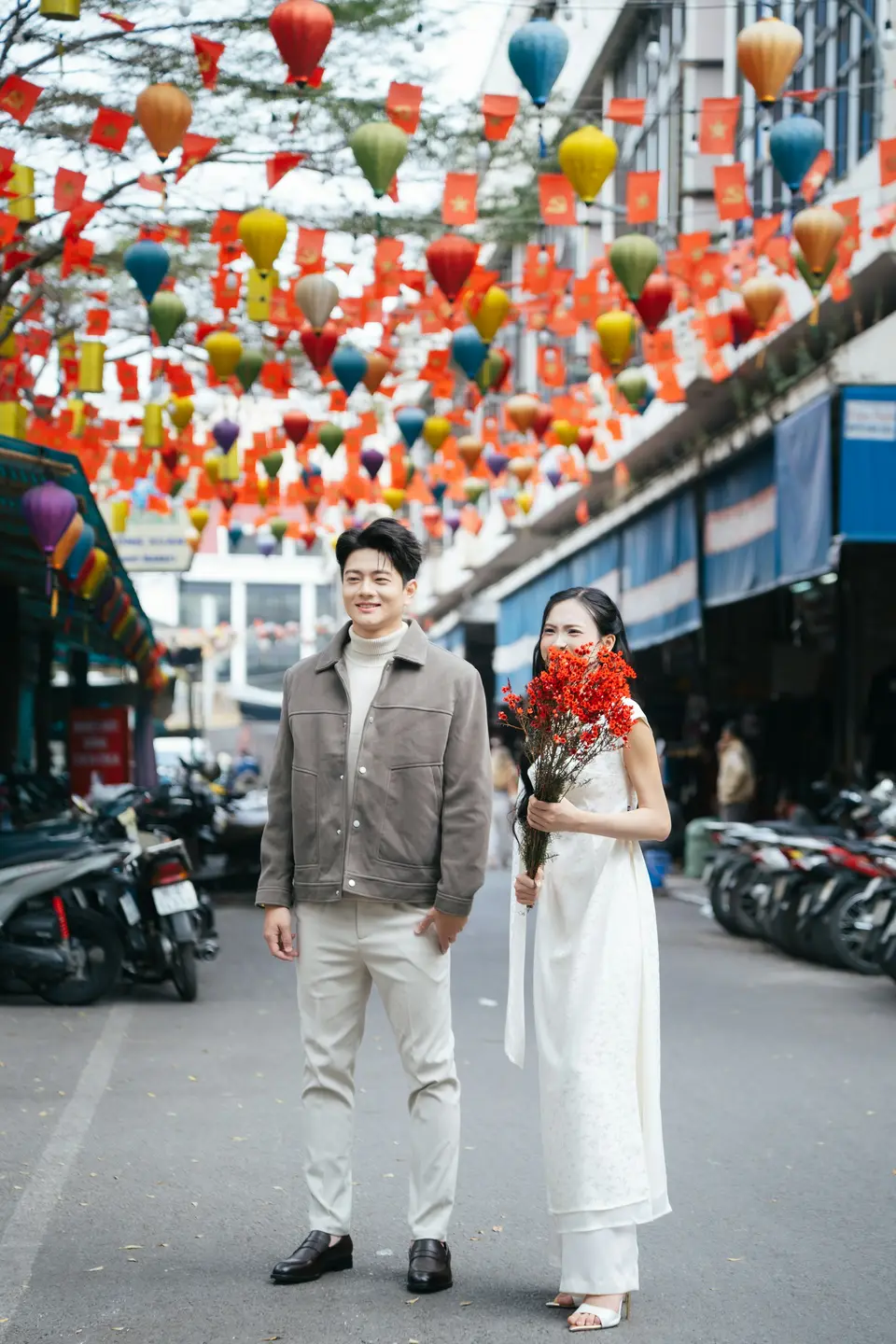 A couple walking hand in hand along a cobbled street in soft evening light