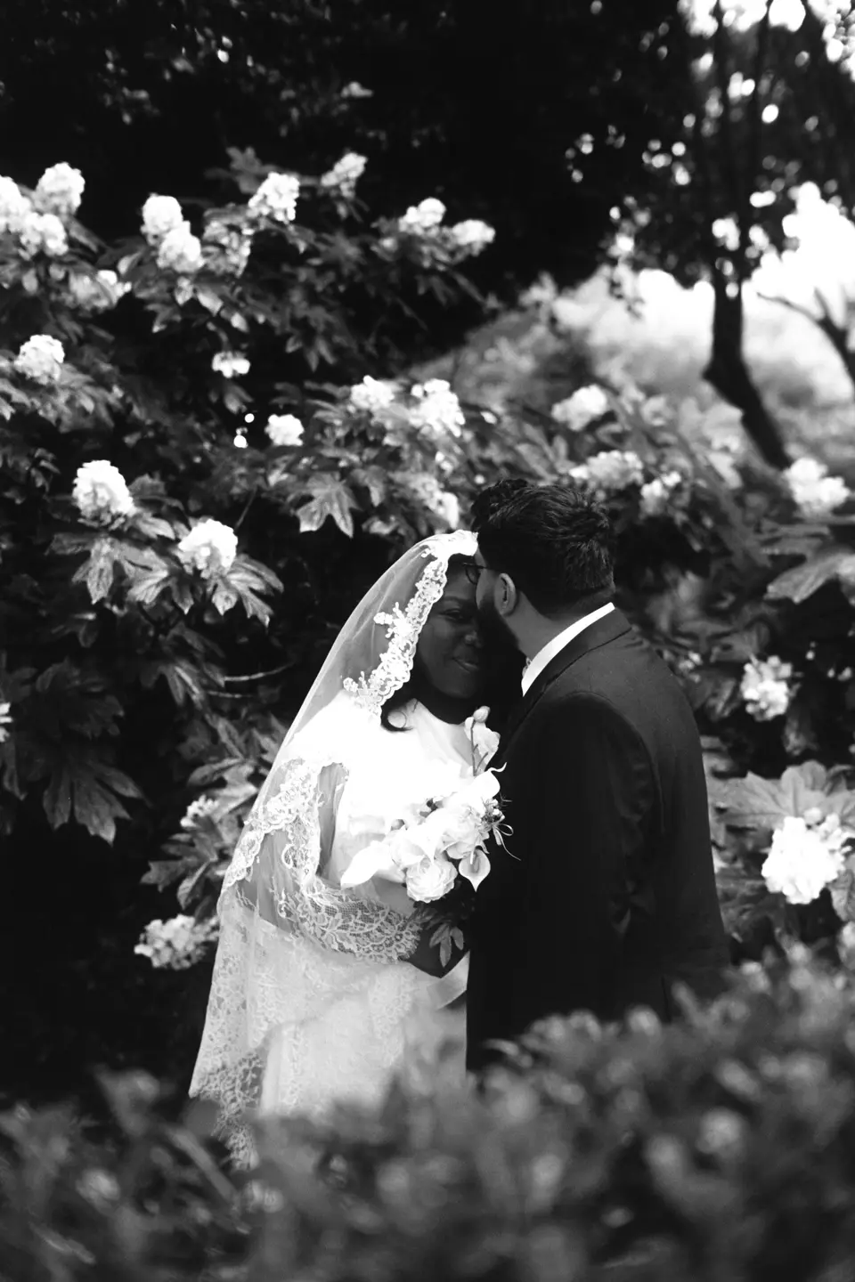 A couple exchanging vows on a hillside above a lake