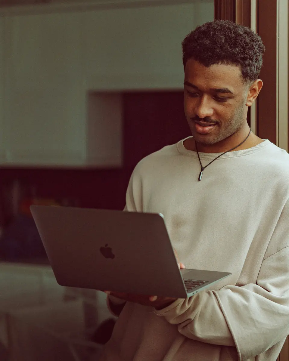A woman working at a laptop in a bright studio, photographed for her brand