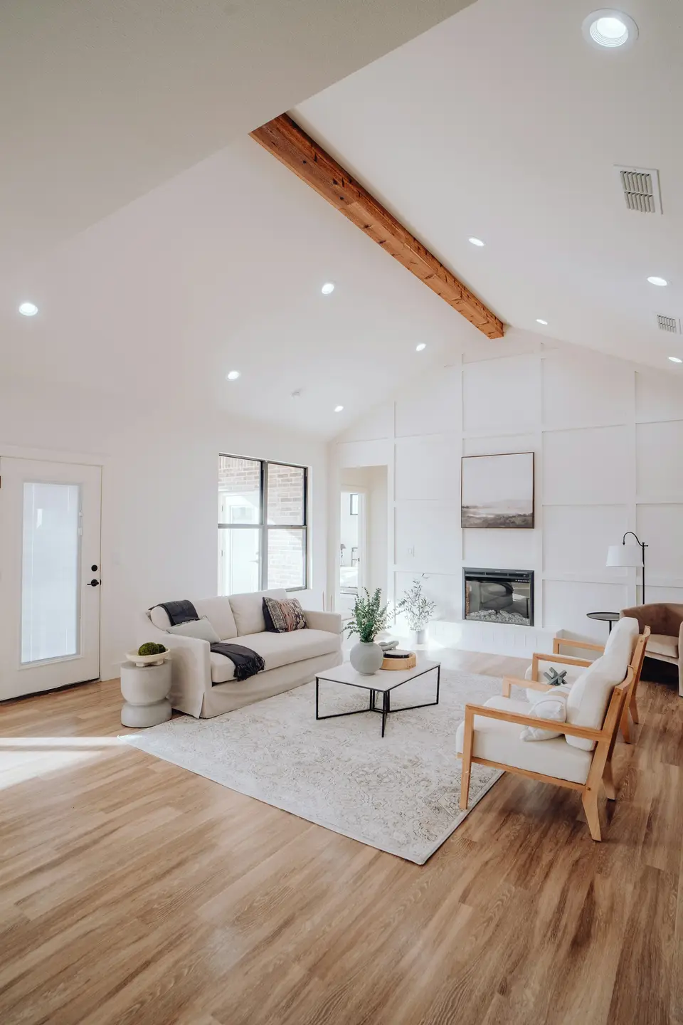 A bright living room with large windows, photographed for a property listing