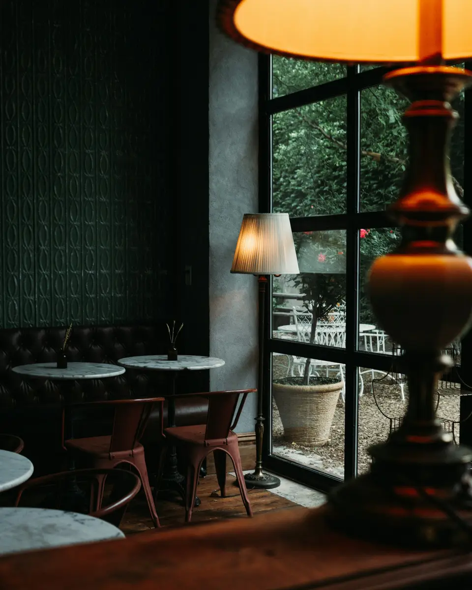 A set restaurant table by a window with plated dishes and wine glasses